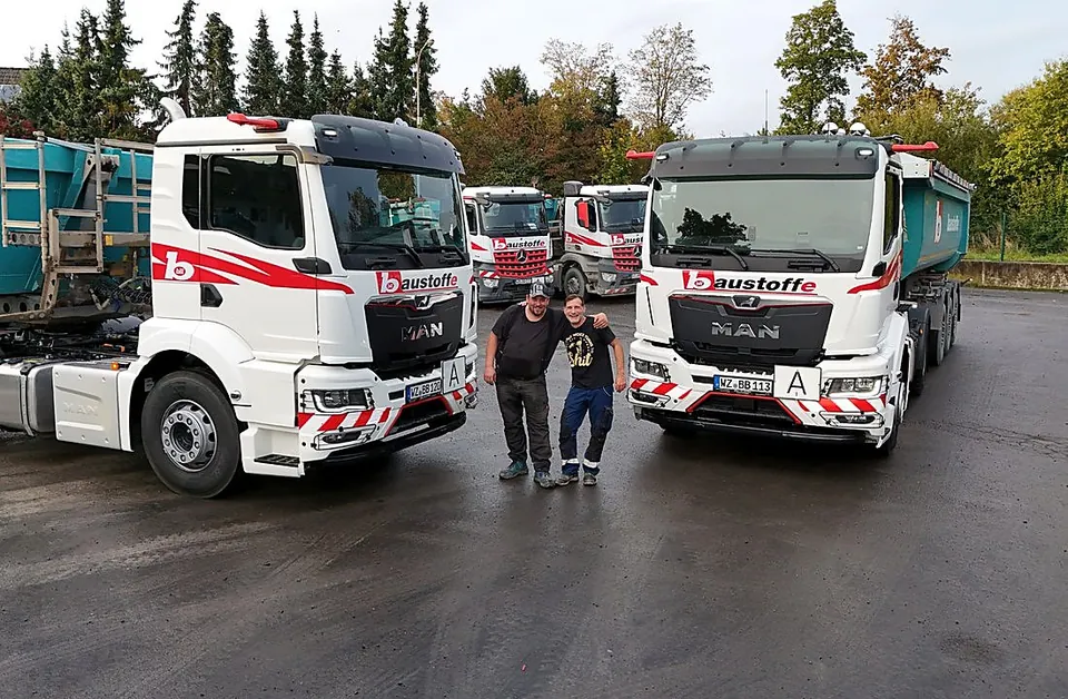 LKW-Fahrer vor Bill-Baustoffe-Fahrzeugen